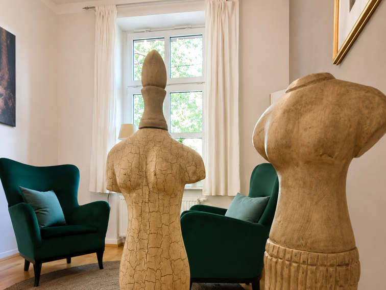 Gesprächsraum mit grünen Sesseln und anatomischen Figuren